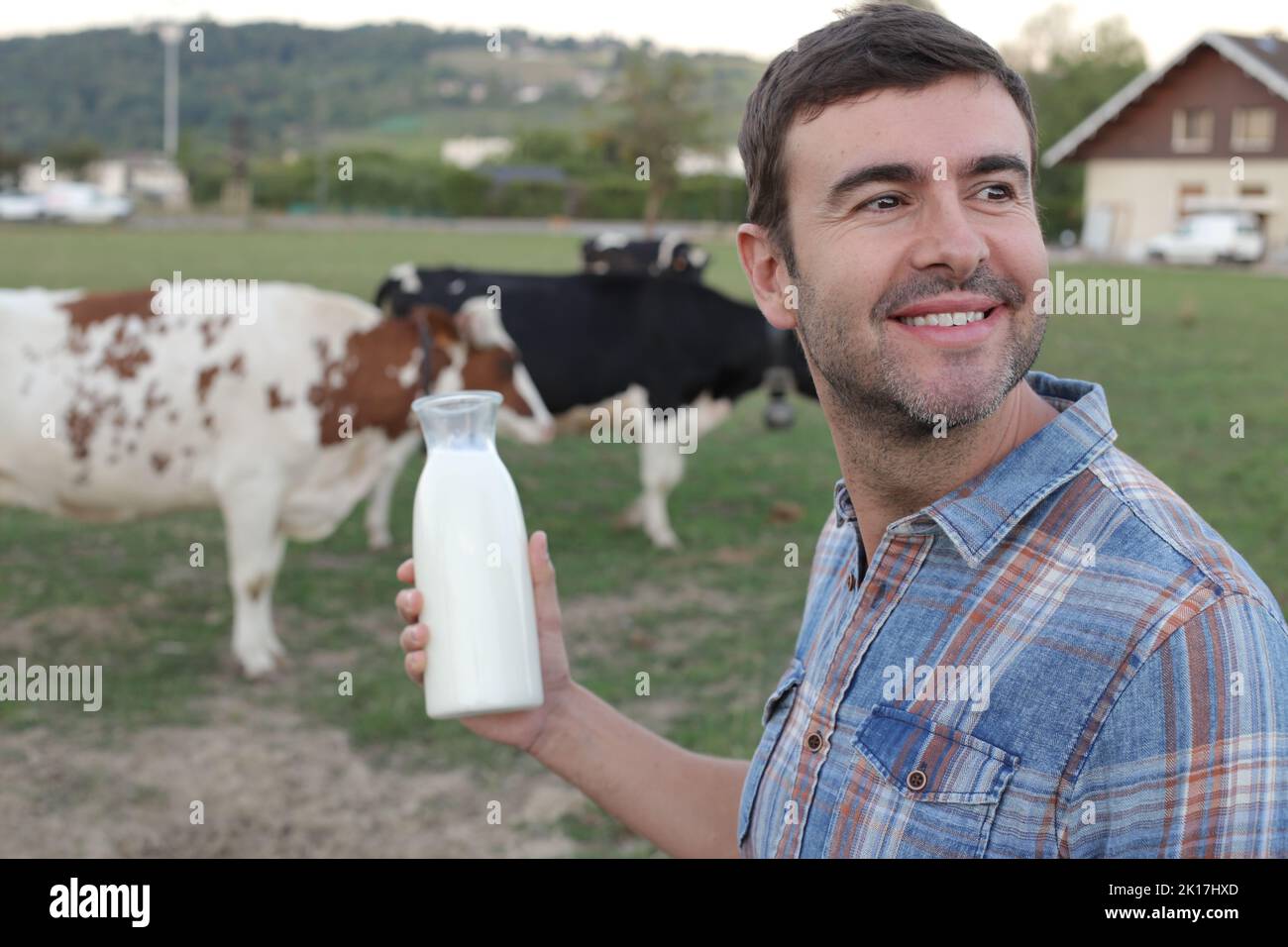 Landwirt mit Kühen im Hintergrund Stockfoto