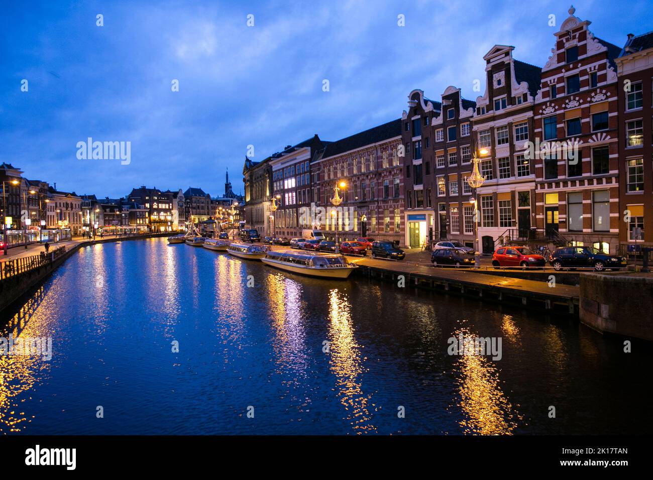 Blick auf Amsterdams Kanal bei Nacht mit Reflexion auf dem Fluss Stockfoto