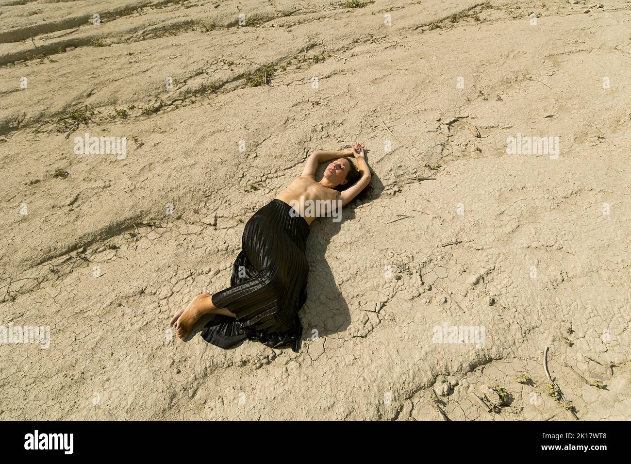 Frau liegt in der Wüste Stockfoto