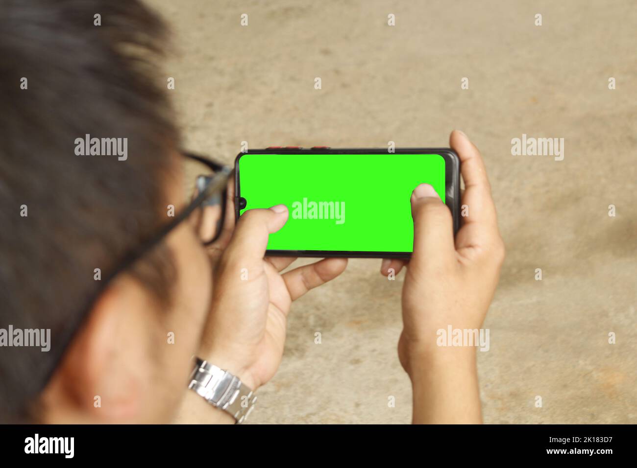 Handy Green Screen , Gameplay-Geste vor dem grünen Bildschirm, Smartphone-Game-Spieler Stockfoto