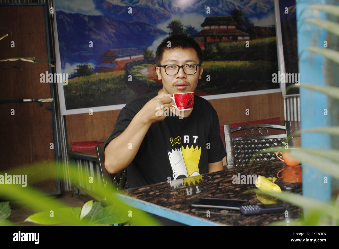 Ein junger Mann trägt Glas und trinkt Tee in der Morgenzeit, trinkt Tee in der Morgenzeit Stockfoto