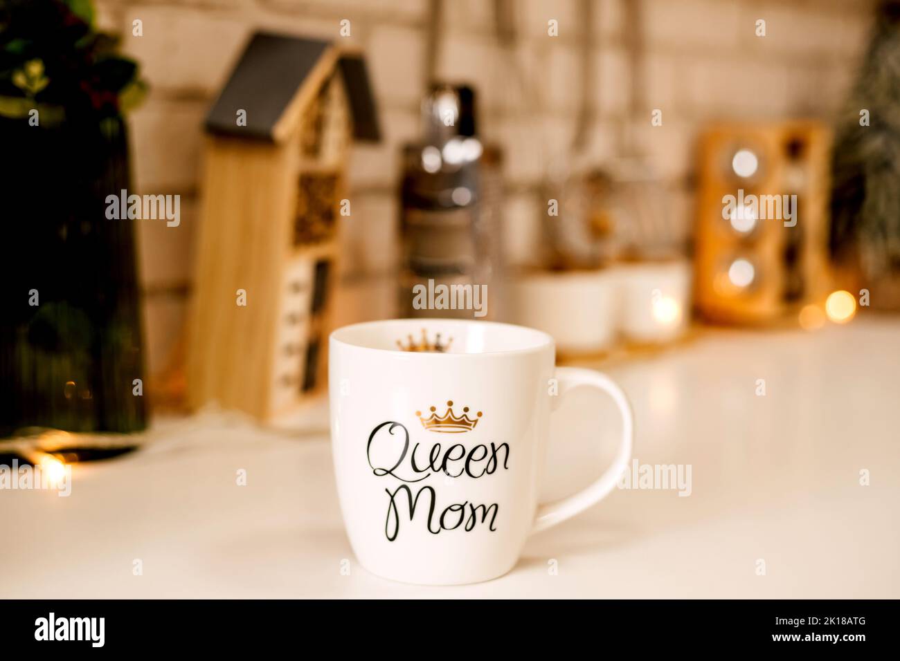 In der Küche steht ein weißer Becher mit der Aufschrift Queen Mama auf dem Tisch Stockfoto