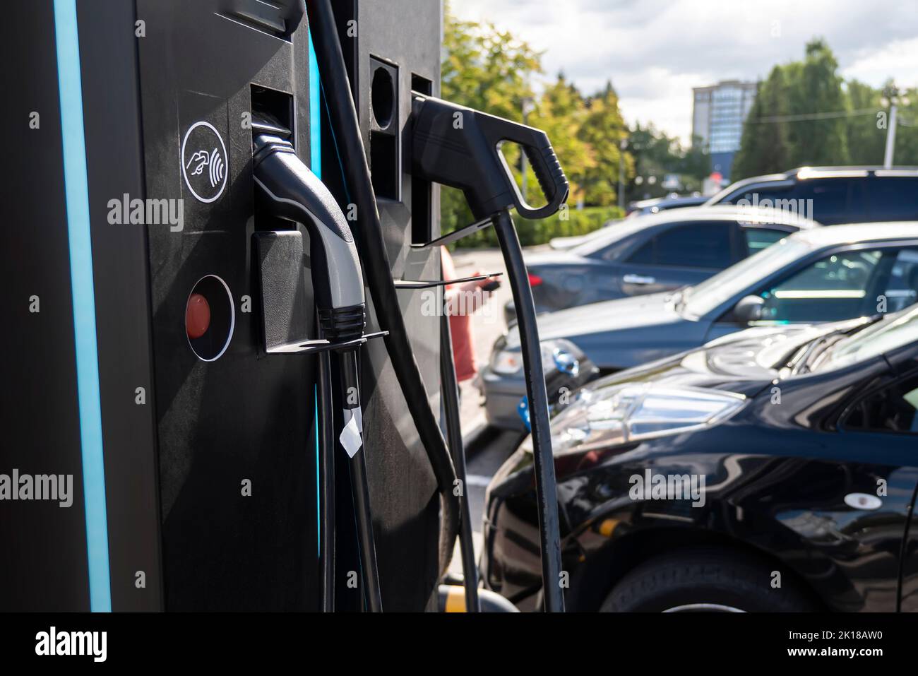 Laden von Batterien eines Elektroautos auf einer Stadtstraße. Tanken für Autos e-Mobility. Laden eines Elektroautos mit Hybrid-Motor Benzin und Elektro Stockfoto