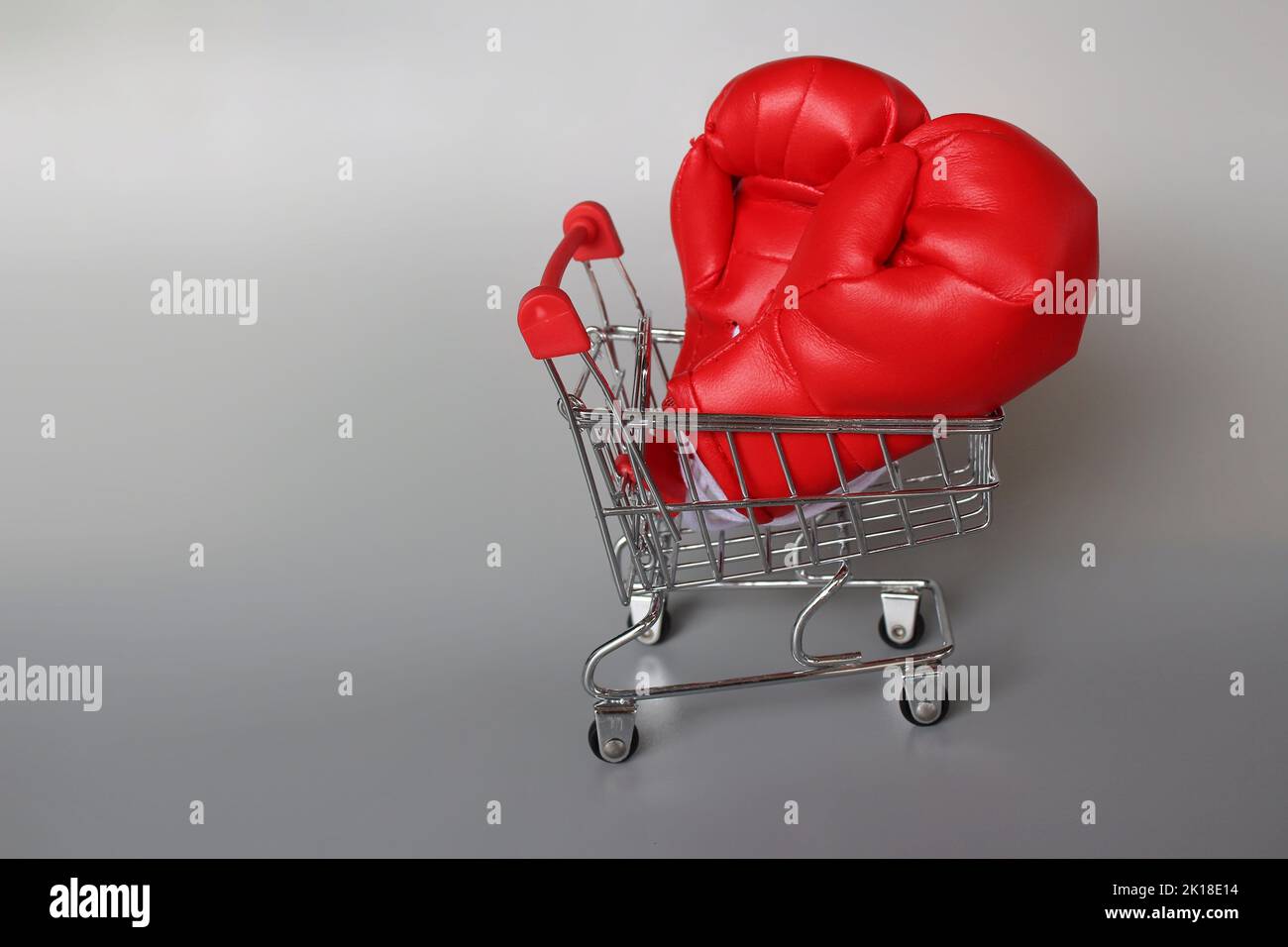 Boxhandschuhe im Einkaufswagen mit Platz für Kopien. Kampf gegen das Inflationskonzept Stockfoto