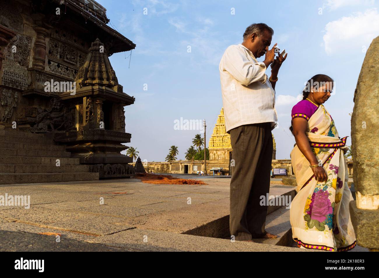 Belur, Karnataka, Indien: Ein Mann und eine Frau stehen neben dem Channakeshava Tempel aus dem 12.. Jahrhundert. Stockfoto