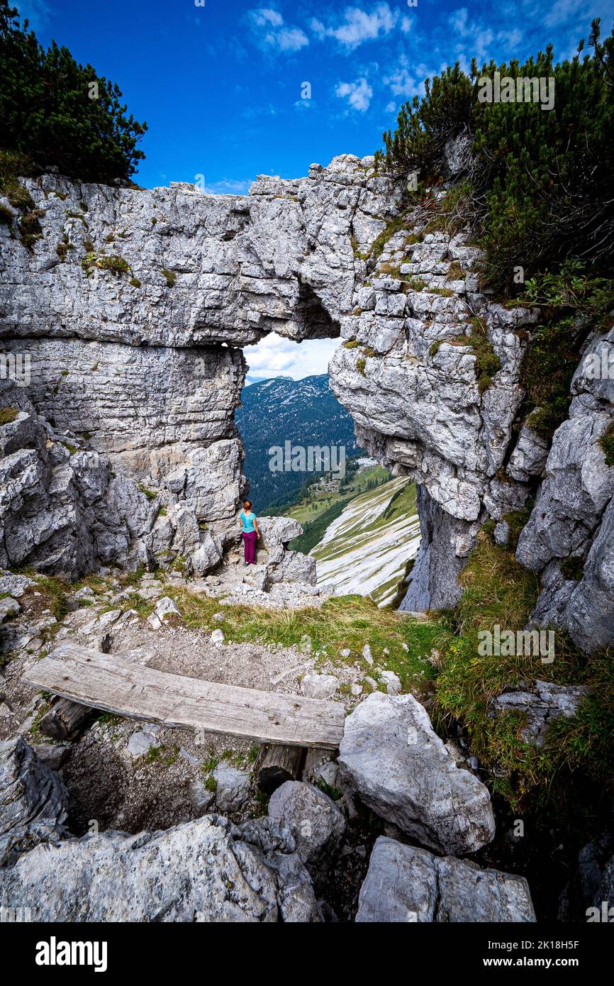 Wanderweibchen genießen den Blick durch das sogenannte Loser-Fenster, einen Felsbogen auf dem Loser Berg, Ausseer Land, Steiermark, Österreich Stockfoto
