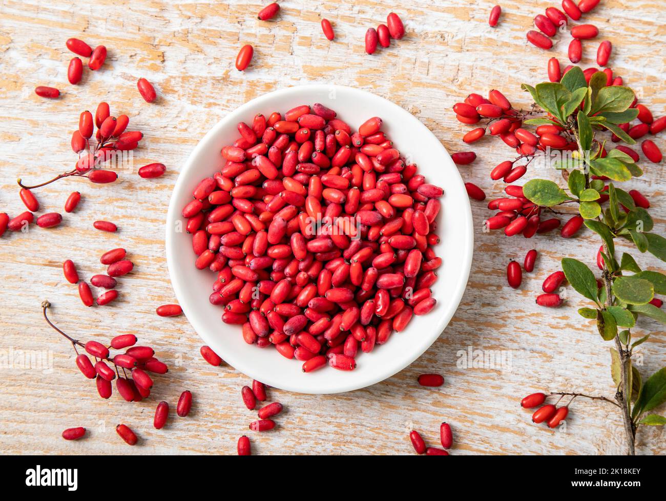 Haufen von Berberis vulgaris auch bekannt als gewöhnliche Berberbeere, Europäische Berberbeere oder Berberbeere auf dem Teller in heimischen Kicthen. Essbare pflanzliche Heilfrucht. Stockfoto