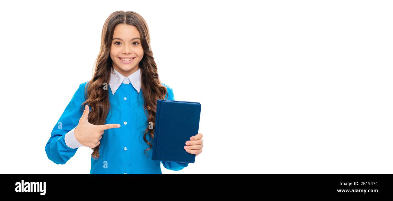 Glückliches Kind zeigen Zeigefinger auf Schulbuch isoliert auf weiß, Werbung. Porträt einer Schülerin, Studio-Banner-Header. Gesicht des Schulkindes Stockfoto