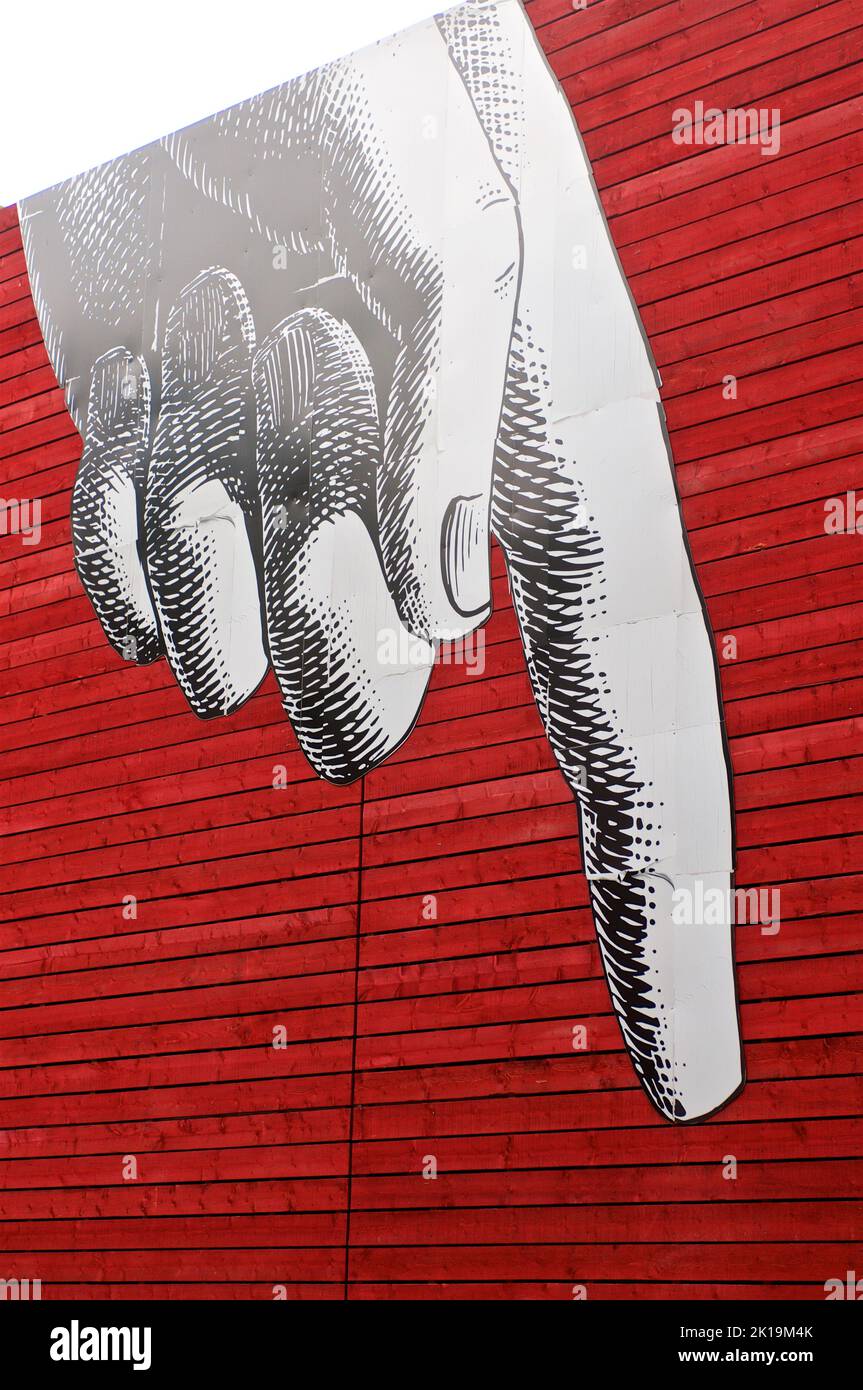 Große Vintage-Illustration mit zeigender Hand auf roter Holzwand in urbaner Umgebung Stockfoto