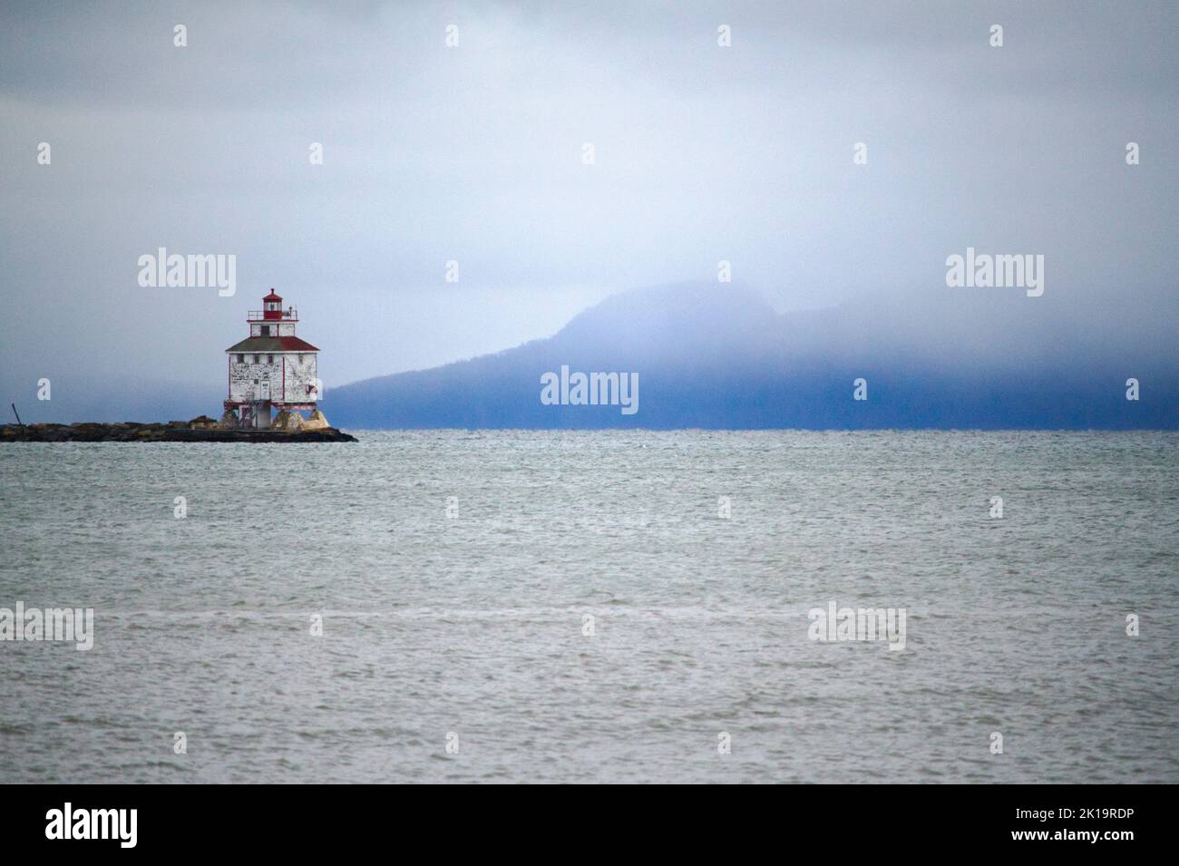 Der Thunder Bay Lighthouse gegen den schlafenden Riesen am Lake Superior an einem nebligen Tag. Stockfoto