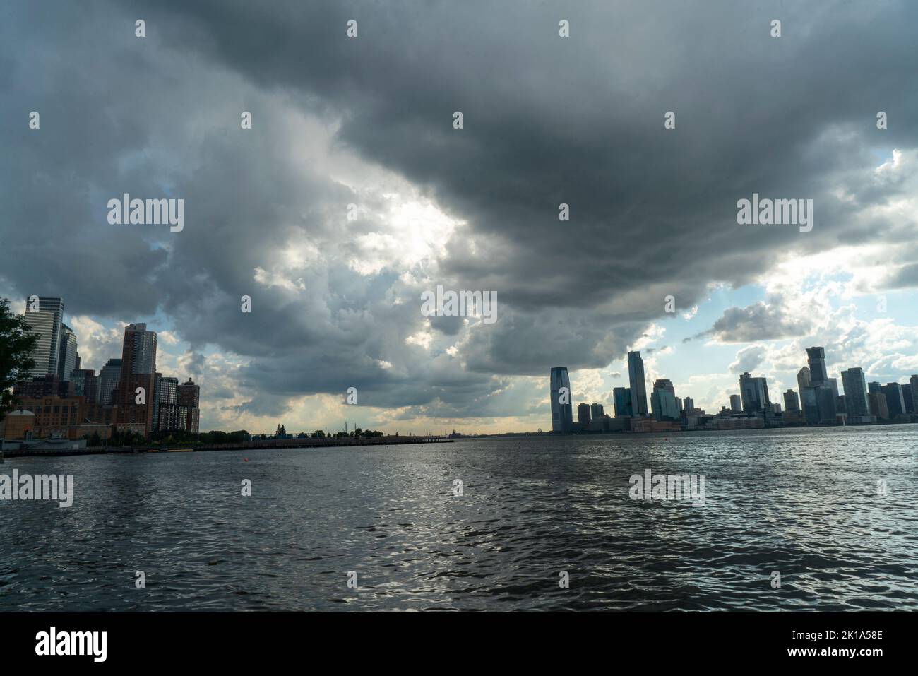 Der Hudson River mit Sturmwolken, der nach Süden in Richtung Battery Park City am Ostufer des Flusses und Jersey City, New Jersey, am Wester blickt Stockfoto