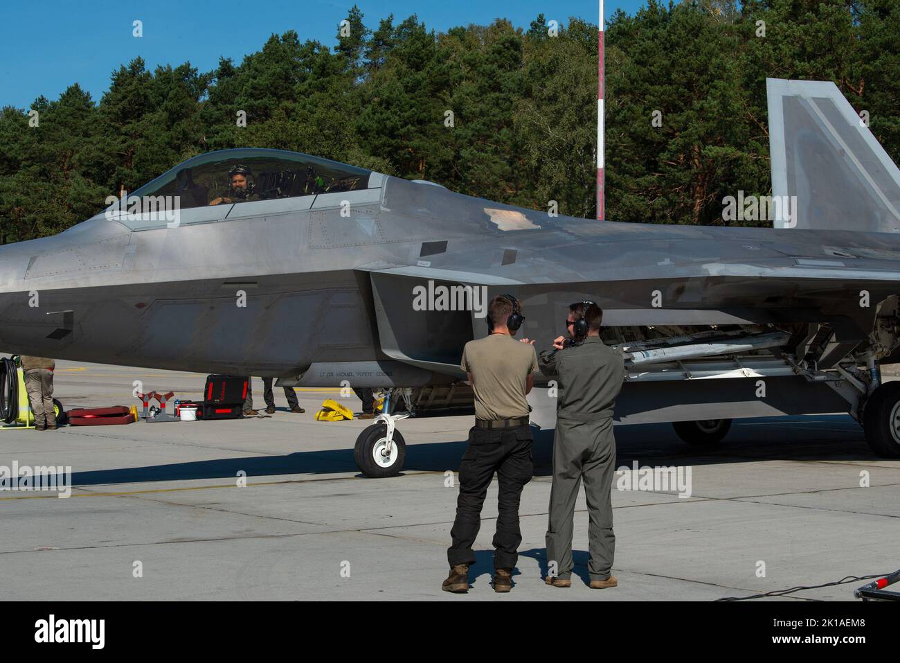 Die US Air Force Airmen 1. Class Thatcher Deese, links, Crew-Chef, und Capt. „Swiss“ Ritschard, F-22 Raptor-Pilot, beide dem Expeditionary Fighter Squadron von 90. zugewiesen, führen einen F-22 Raptor an, um während Ritschards ‘Crew Chief für ein eintägiges Eintauchen auf dem Luftwaffenstützpunkt Łask, Polen, am 5. September 2022, zu parken. ‘Crew Chief for a Day“ ermöglicht es Piloten, sich durch tägliche Aufgaben wie Inspektionen, Bergung und Betankung mit dem Wartungspersonal zu integrieren. Das Eintauchen trägt dazu bei, die Moral und den Teamaufbau innerhalb der Staffel zu stärken. Die Präsenz der 90. in der Region stärkt die Einheit der USA und der NATO jeden Tag, wenn die Streitkräfte zusammenkommen Stockfoto