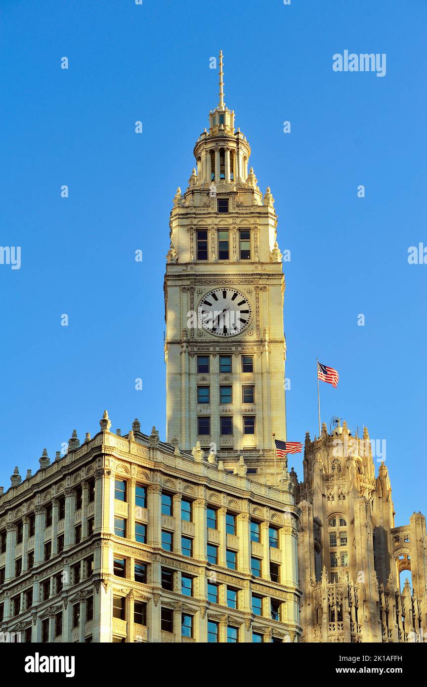 Chicago, Illinois, USA. Wrigley Building und Tribune Tower zusammen mit ausgestellten amerikanischen Flaggen an einem kalten Herbstmorgen. Stockfoto