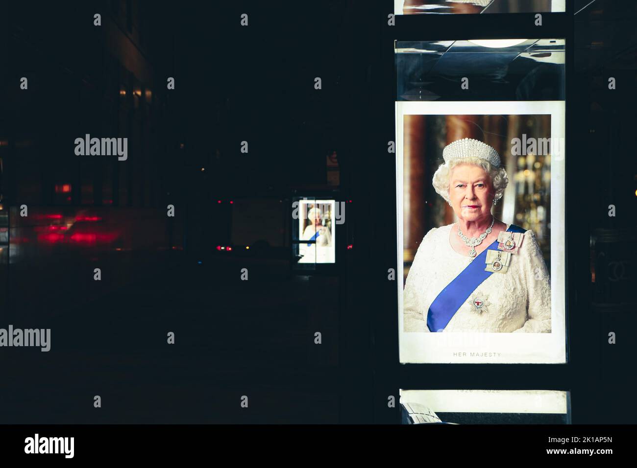 Eine Plakatwand für eine Bushaltestelle in London, nachdem ihre Majestät, Königin Elizabeth II., vor dunklem Hintergrund starb Stockfoto