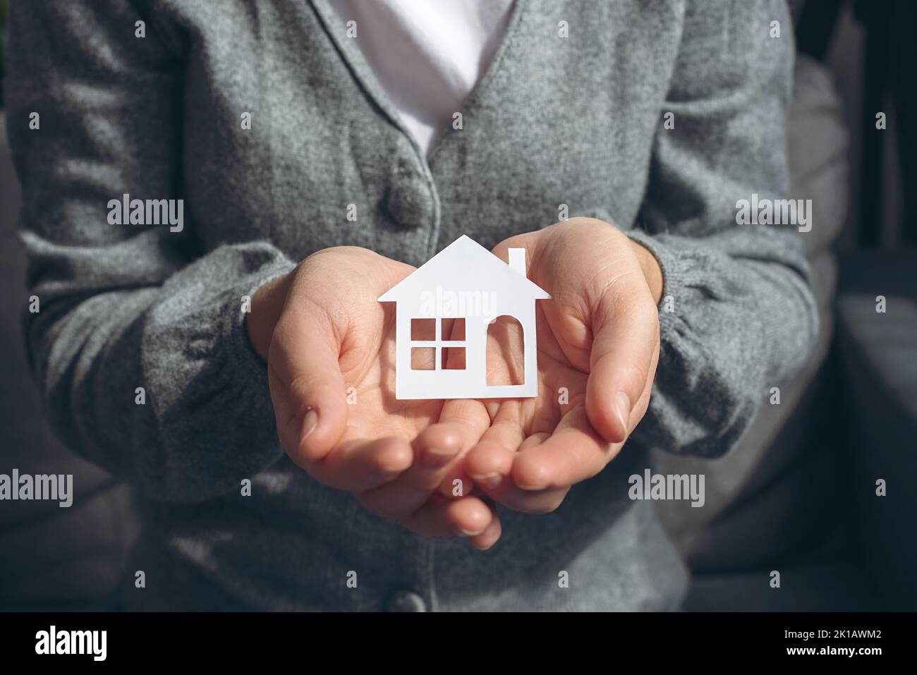 Internationaler Tag der Familien, Pflege zu Hause, häusliche Betreuung, soziale Distanzierung. Frau Hände halten weißes Papierhaus Modell, Familie zu Hause, obdachlos Stockfoto