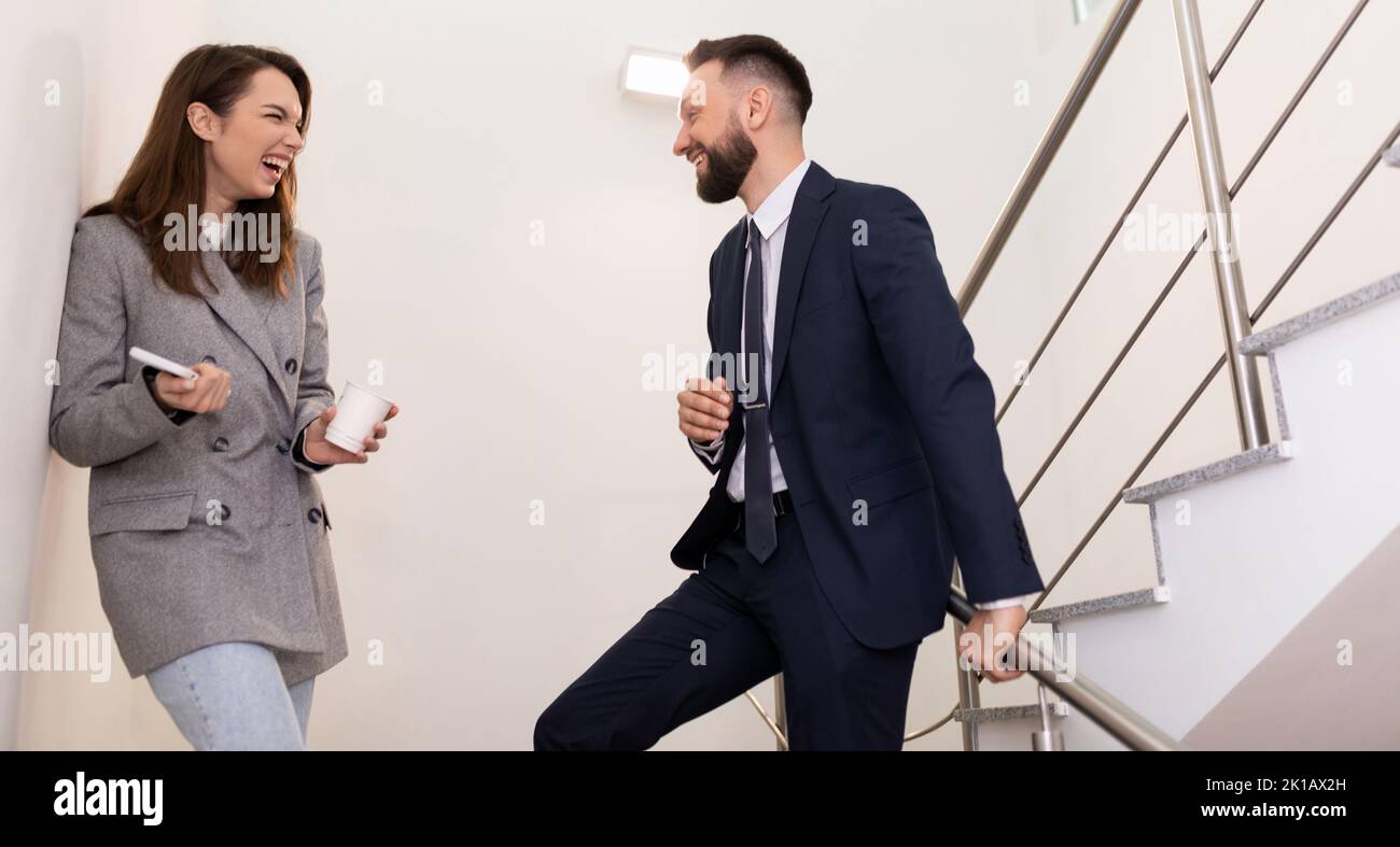 Büroangestellte lachen und diskutieren während ihrer Arbeitspause über den neuesten Klatsch Stockfoto