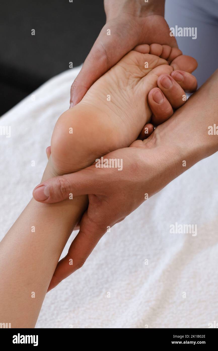 Fußmassagebehandlung für Kinder durch professionellen Masseur im Spa-Resort. Wellness, Stressabbau und Gesundheitskonzept Stockfoto