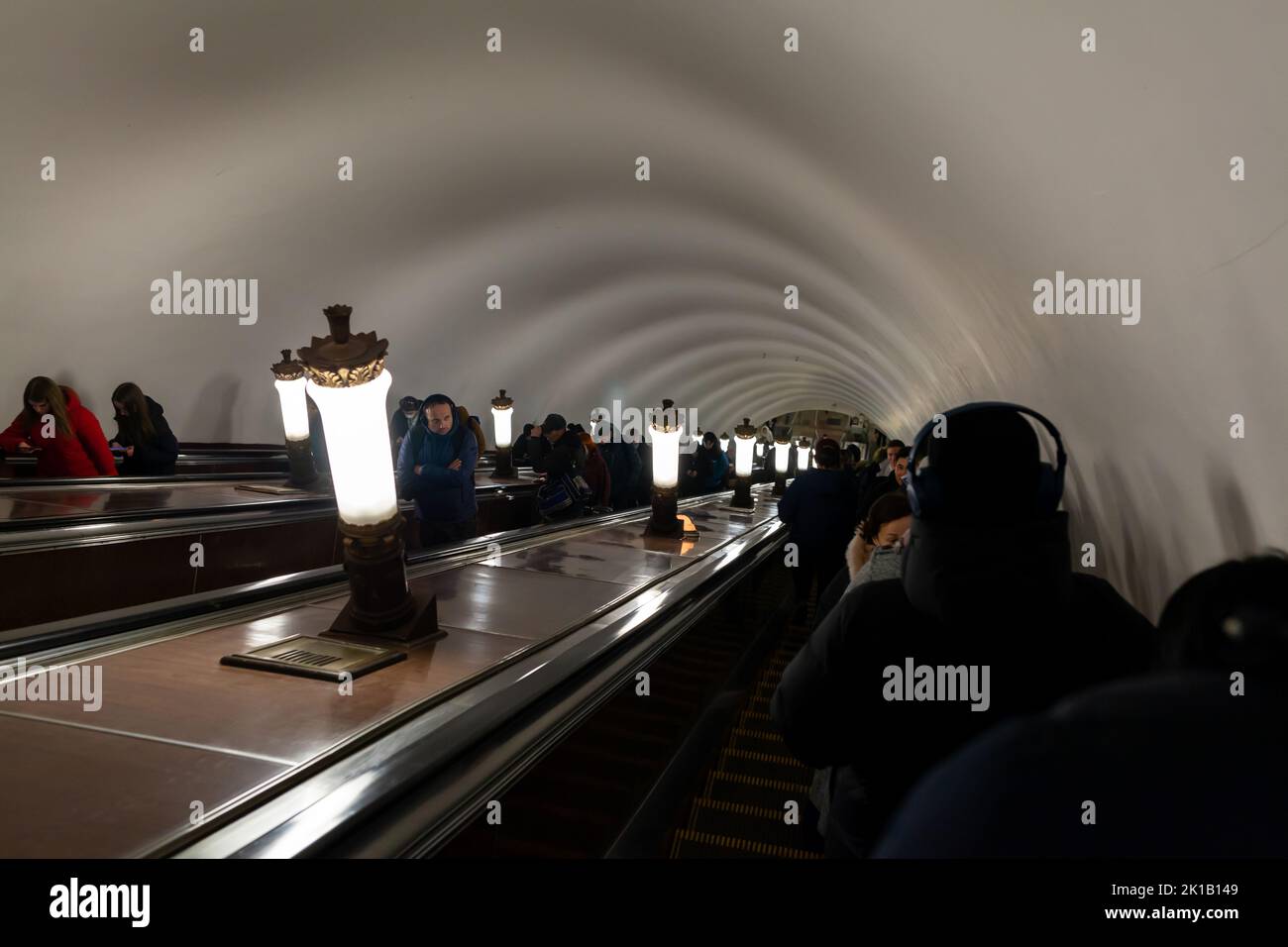 Die Leute gehen die Rolltreppe zur U-Bahn-Station hoch oder runter. Stadtleben Stockfoto
