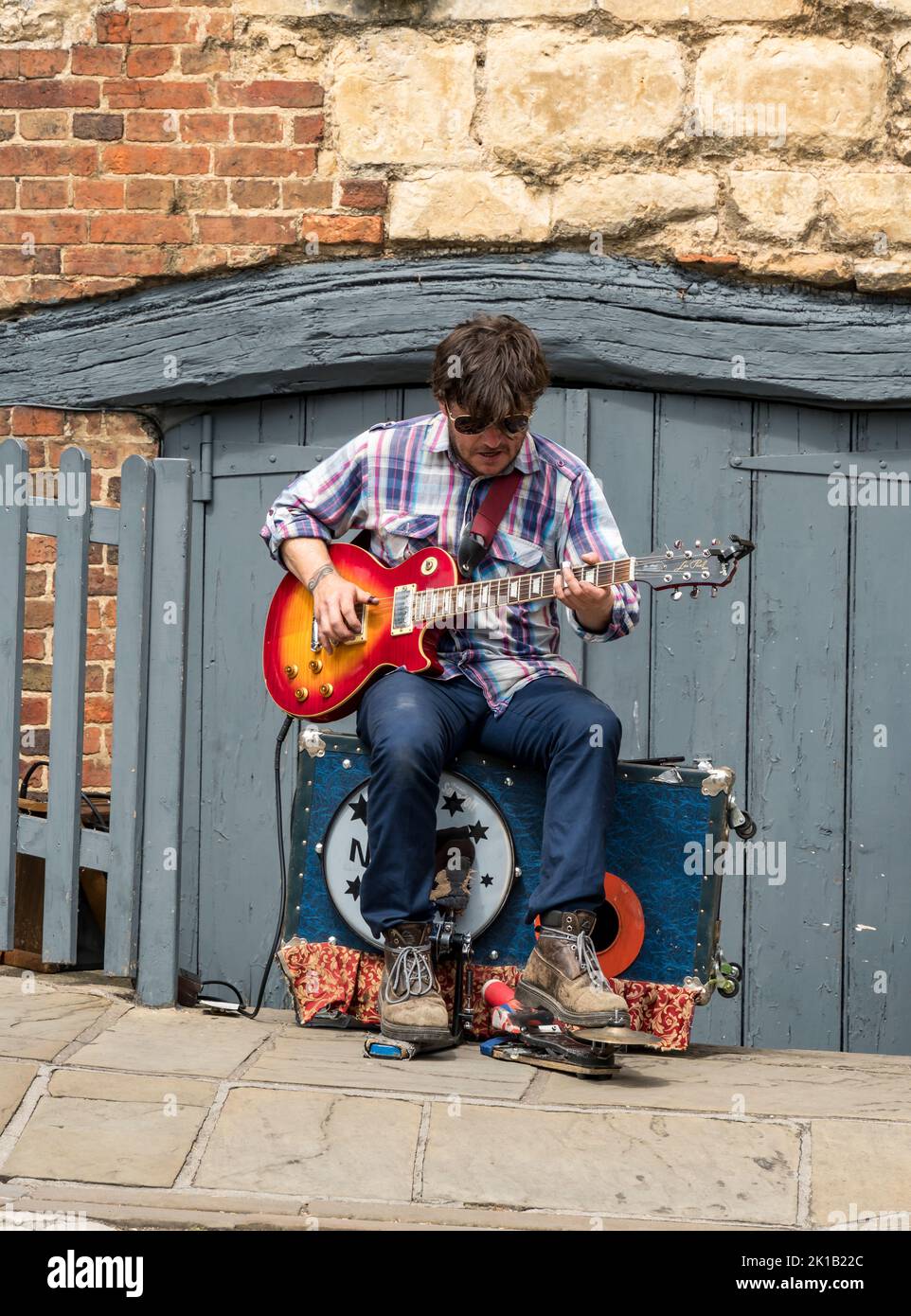 Busker spielt E-Gitarre mit anderen Instrumenten Selbstbegleitung Stockfoto
