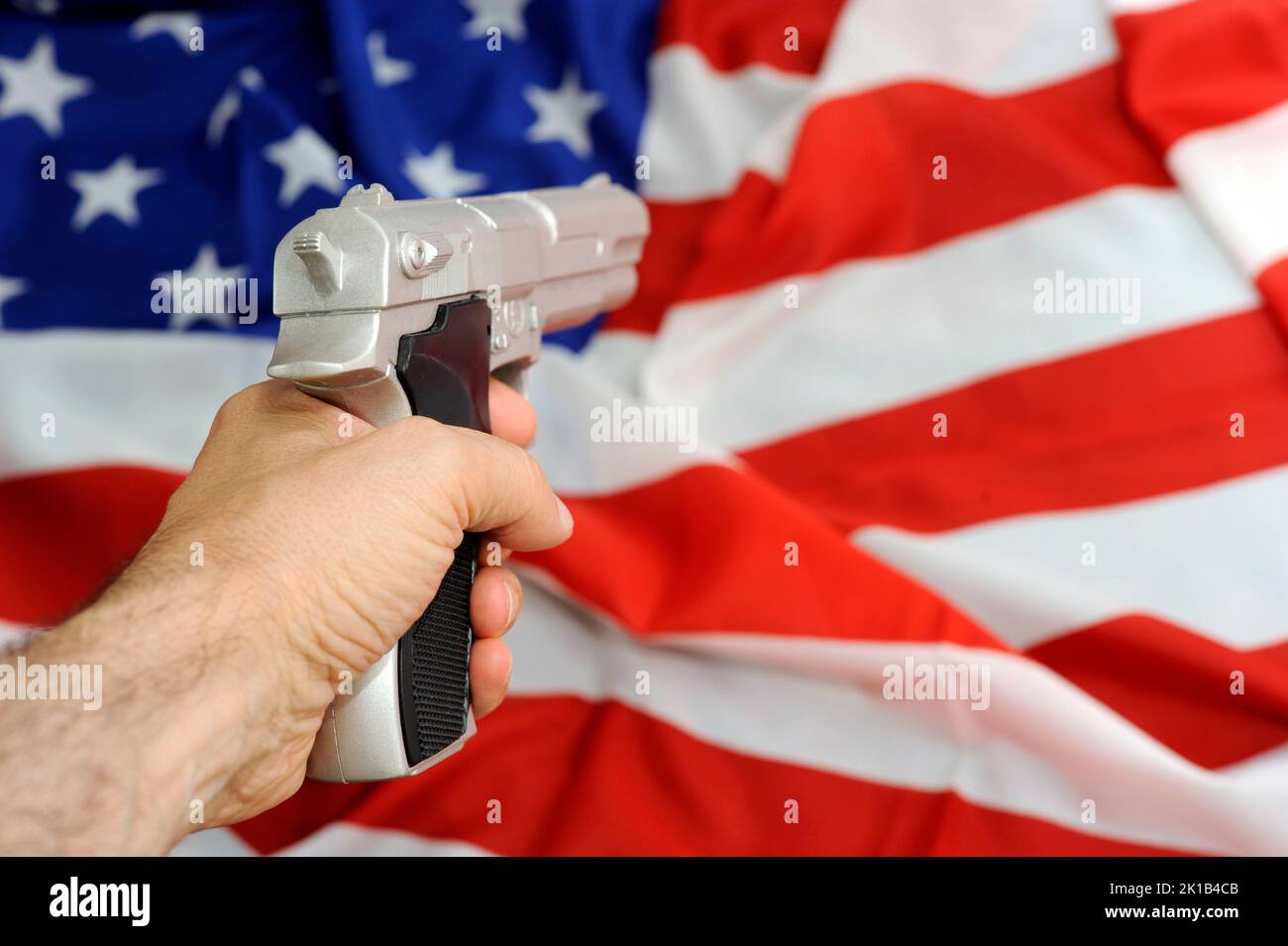 Flagge der USA und Waffe, Problem der Waffenkontrolle in den Vereinigten Staaten Stockfoto