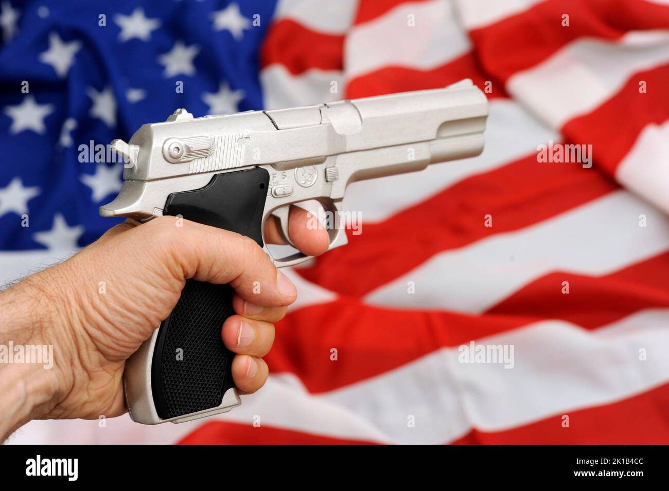 Flagge der USA und Waffe, Problem der Waffenkontrolle in den Vereinigten Staaten Stockfoto