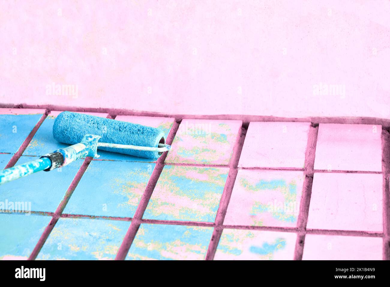Rollerlackierung rosa Wandoberfläche mit azurblauer Farbe Stockfoto