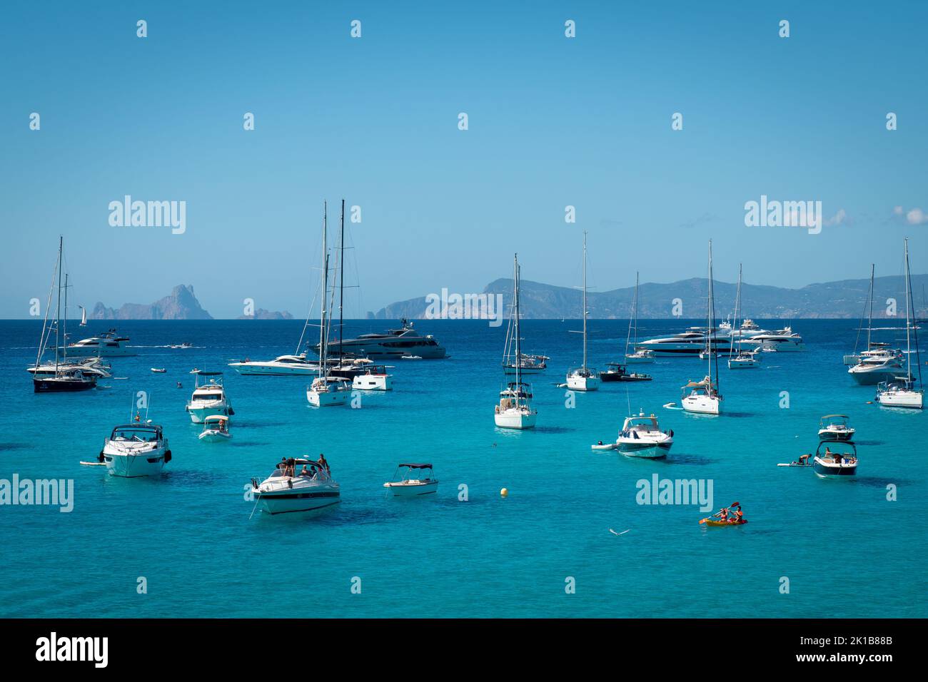 Boote ankerten in Cala Saona mit Es Vedra im Hintergrund Stockfoto