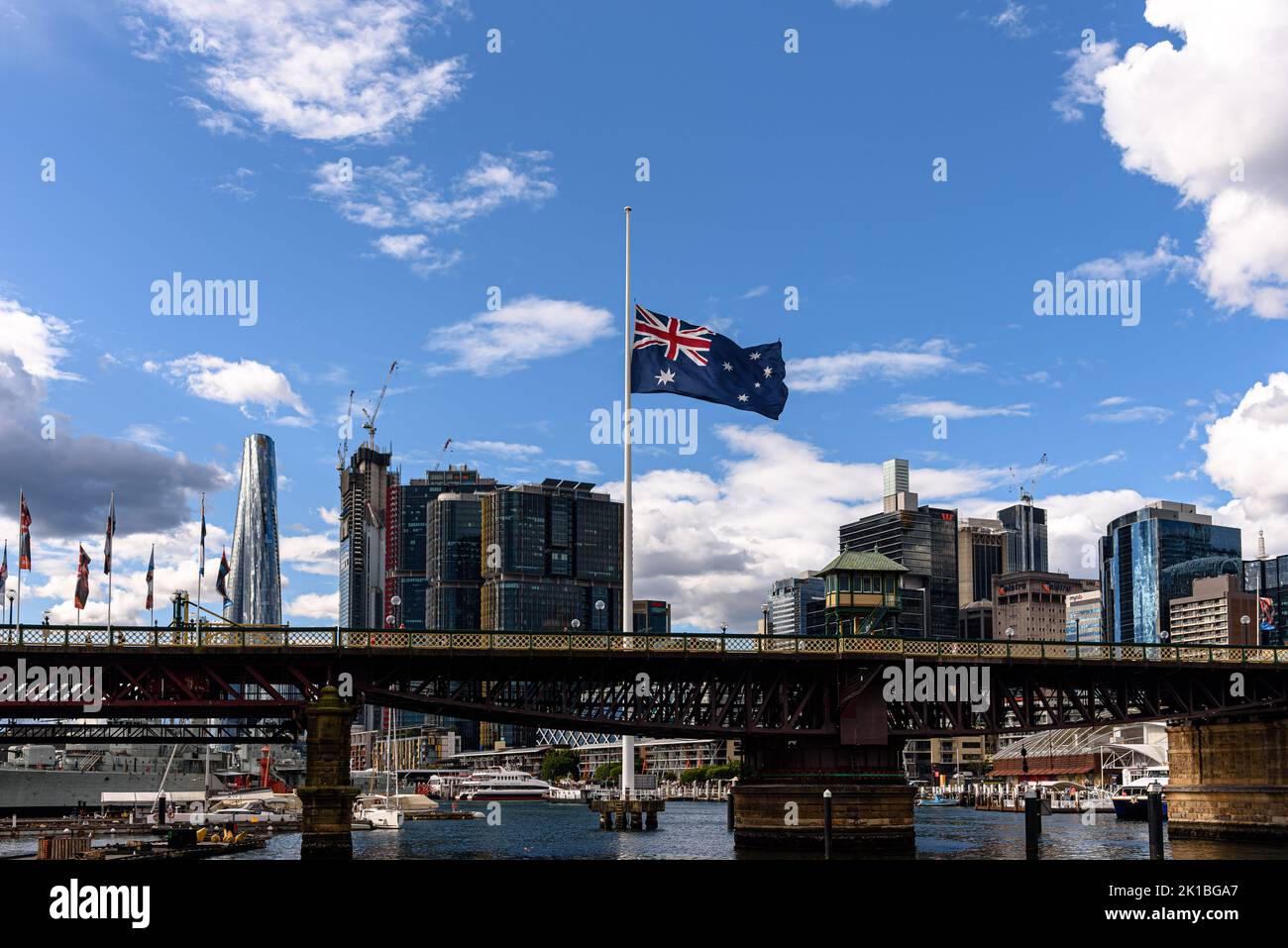 Die Pyrmont Bridge über Darling Harbour in Sydney mit der australischen Flagge am Halbmast Stockfoto