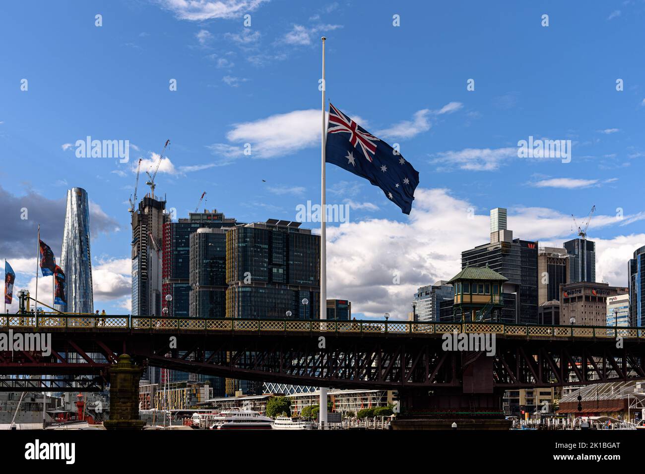 Die Pyrmont Bridge über Darling Harbour in Sydney mit der australischen Flagge am Halbmast Stockfoto