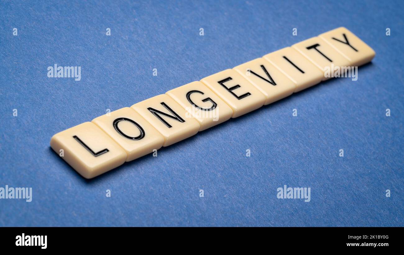 Longevity Wort in Elfenbein Buchstaben Fliesen gegen strukturierte handgemachte Papier, Lebensdauer und healthspan Konzept Stockfoto