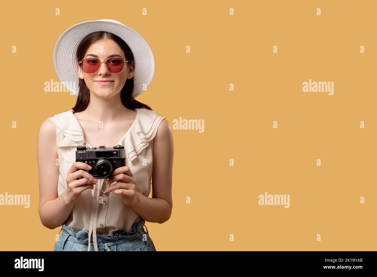 Urlaubsreise. Halten Sie Momente fest. Sommererinnerungen. Lächelnde Frau Sonnenbrille Hut halten Retro-Kamera bereit Foto machen gerade auf beig isoliert aussehen Stockfoto