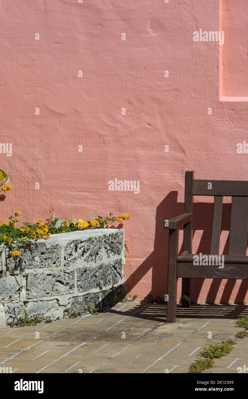 Bermuda-Architektur Lachsfarbengebäude & Holzbank Licht & Schatten Abstrakt Nahaufnahme Stockfoto