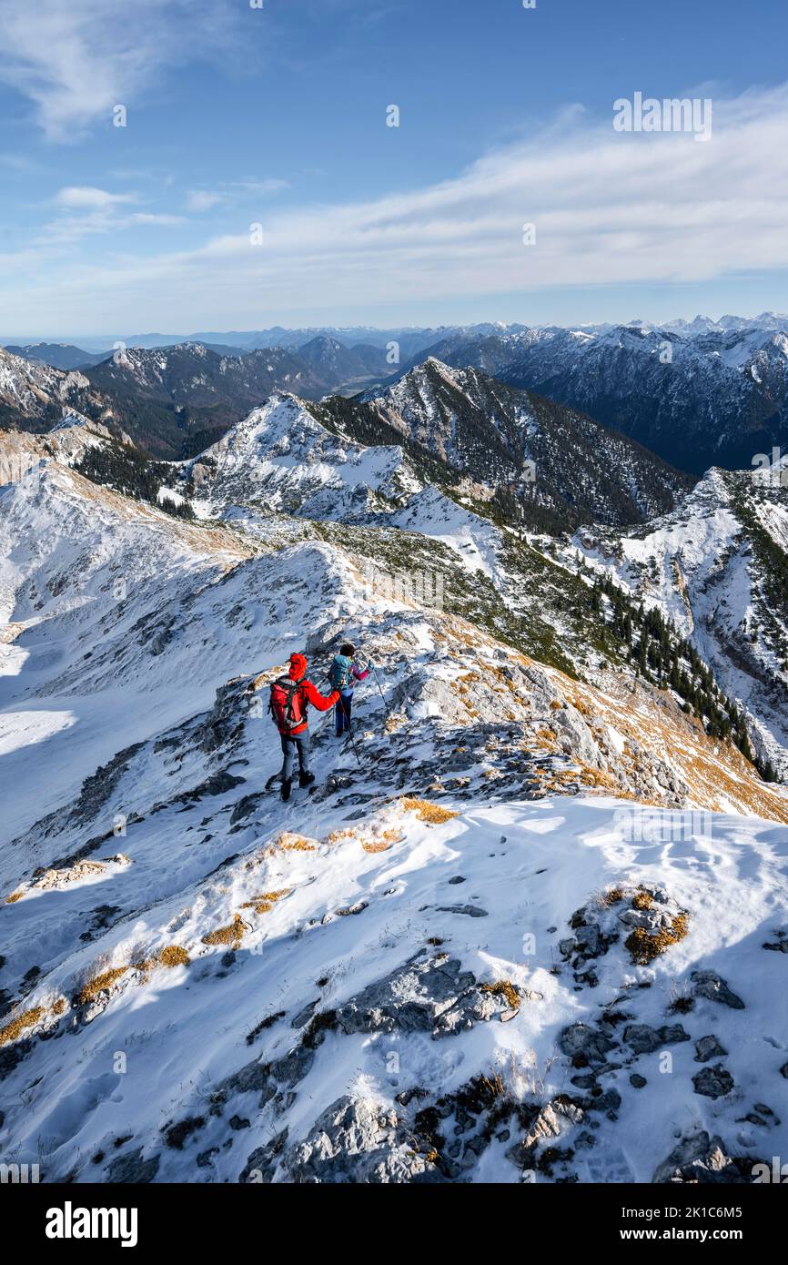 Zwei Bergsteiger auf dem schmalen felsigen verschneiten Grat der Ammergauer Hochplatte, Blick auf das Bergpanorama, Wanderung zur Ammergauer Hochplatte, in Stockfoto