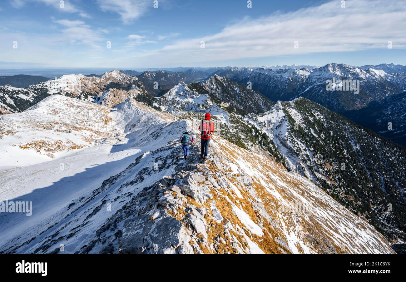Zwei Bergsteiger auf dem schmalen felsigen Schneegrat der Ammergauer Hochplatte, Blick Richtung Loesertaljoch, Blick auf das Bergpanorama, Wanderung zum Stockfoto