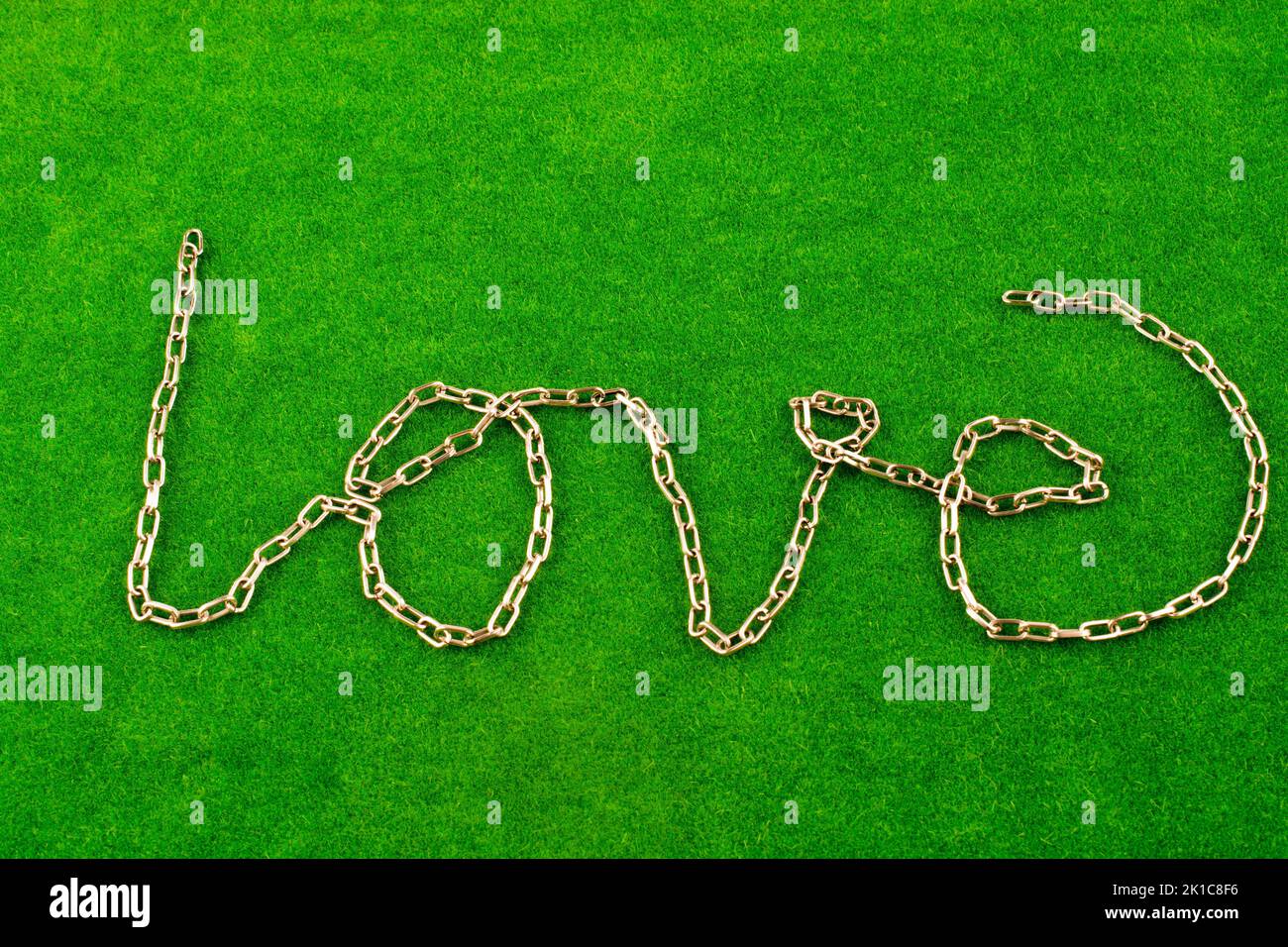 Kette schreibt das Wort Liebe auf dem grünen Rasen Stockfoto