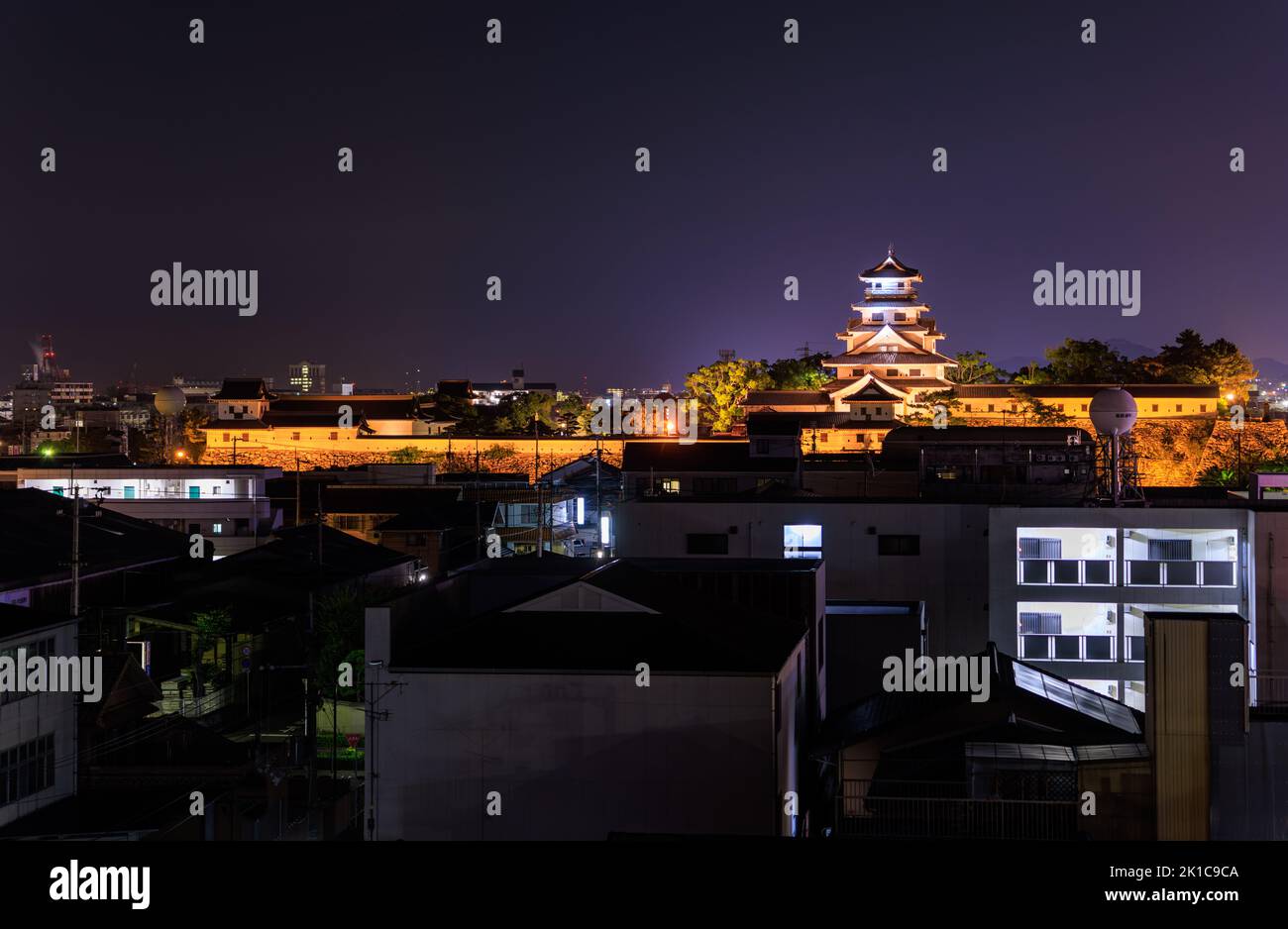 Die Burg Imabari überragt nachts die ruhige Nachbarschaft Stockfoto