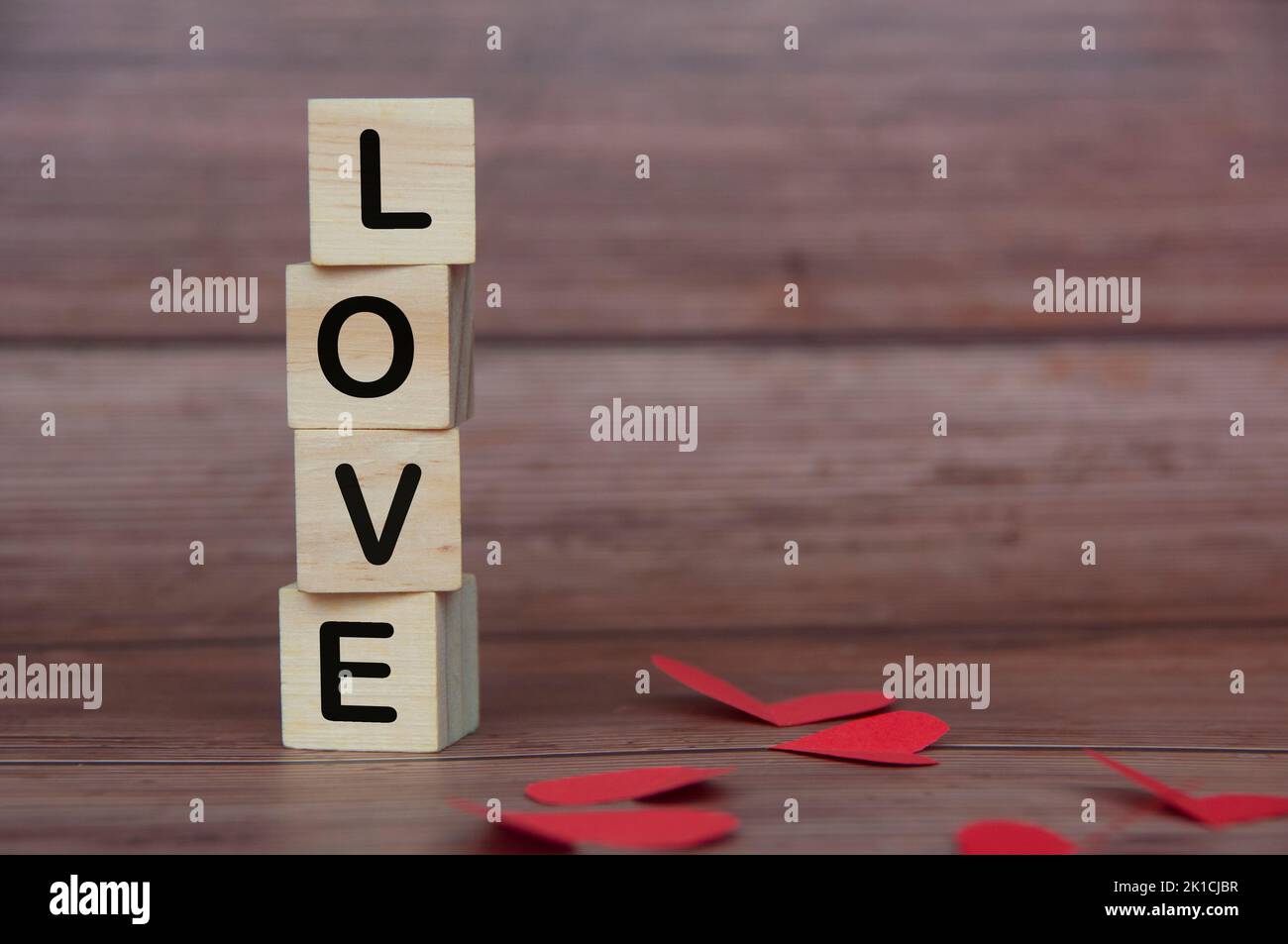 Liebessext auf gestapelten Holzblöcken mit Herzform und Holzhintergrund. Romantik und Beziehungskonzept. Stockfoto