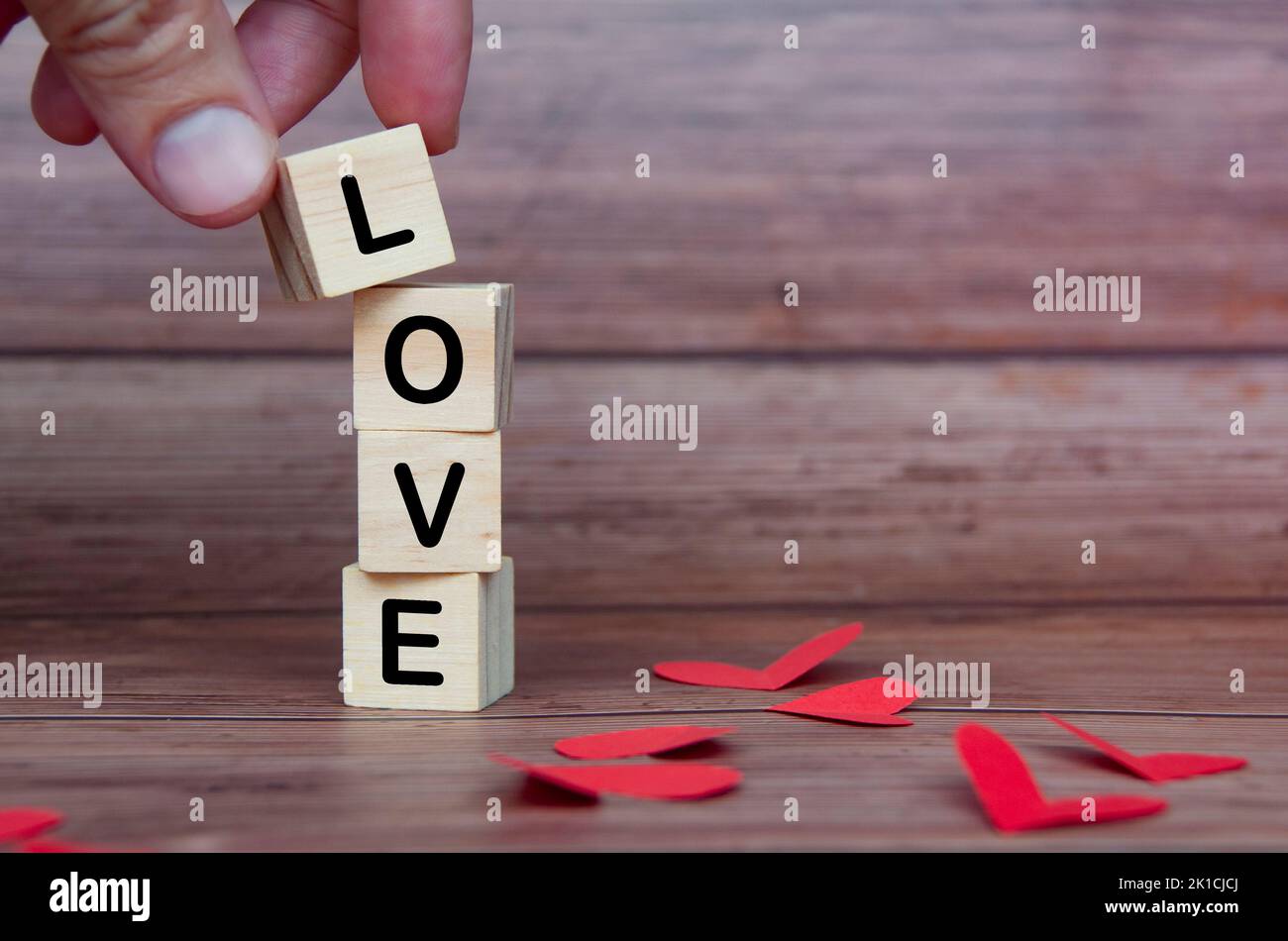 Liebessext auf Holzblöcken mit Herzform und Holzhintergrund. Romantik und Beziehungskonzept. Stockfoto