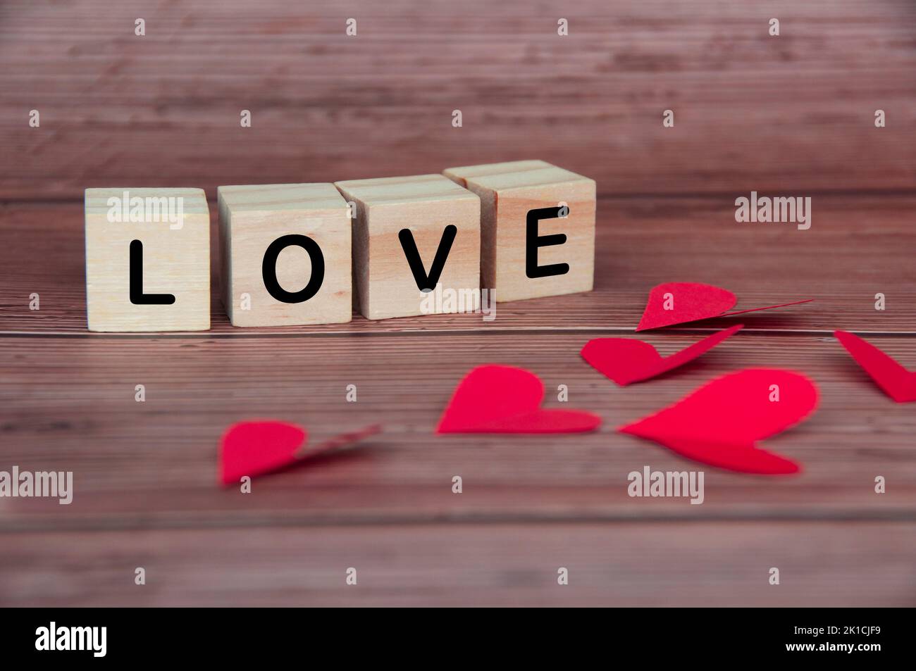 Liebessext auf Holzblöcken mit Herzform und Holzhintergrund. Romantik und Beziehungskonzept. Stockfoto