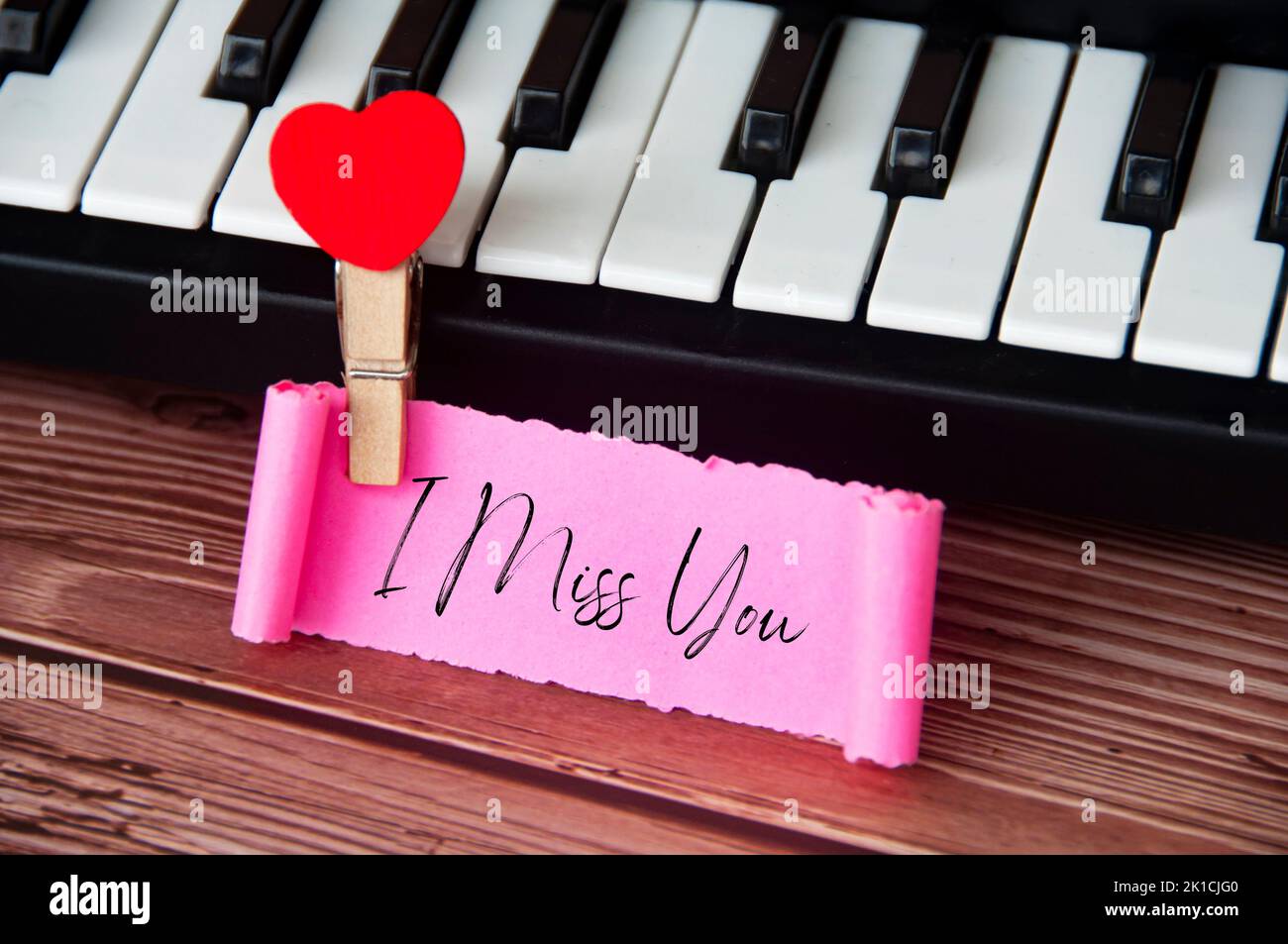 Ich vermisse Sie Text auf zerrissenen rosa Papier mit Tastatur Hintergrund. Romantik und Beziehungskonzept. Stockfoto
