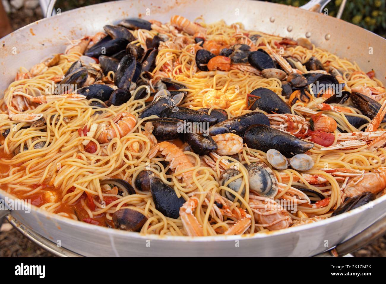 Italienische Spaghetti allo scoglio, Pasta mit Meeresfrüchten und Tomaten in einer Pfanne aus nächster Nähe. Mediterrane apulische traditionelle Küche mit frisch geschmorten cla Stockfoto