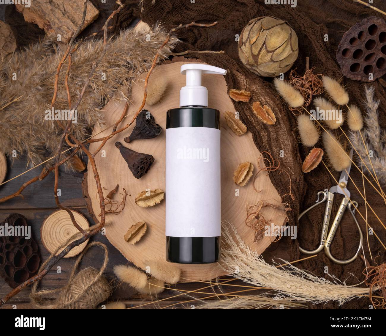 Nachfüllbare eine Pumpflasche auf Holz in der Nähe von natürlichen Boho Dekorationen Draufsicht, Etikett Mockup. Hautpflegeprodukt, Lotion oder Essenz. Böhmische Öko-Frie Stockfoto
