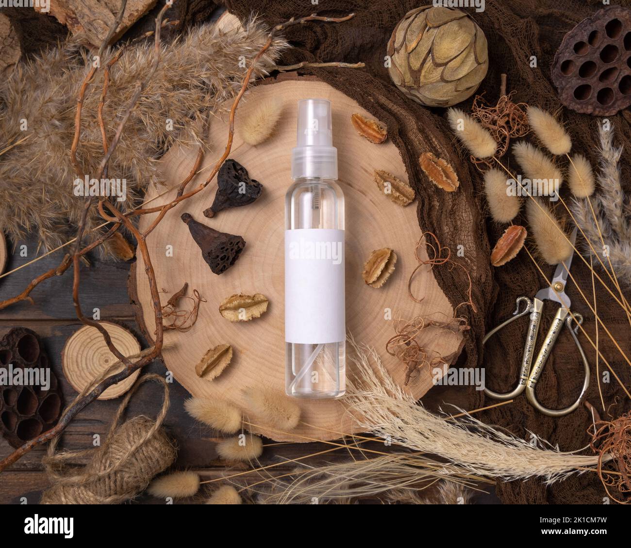 Transparente nachfüllbare Sprühflasche auf Holz in der Nähe von natürlichen Boho Dekorationen Draufsicht, Label Mockup. Hautpflegeprodukt, Lotion oder Essenz. Böhmisch Stockfoto