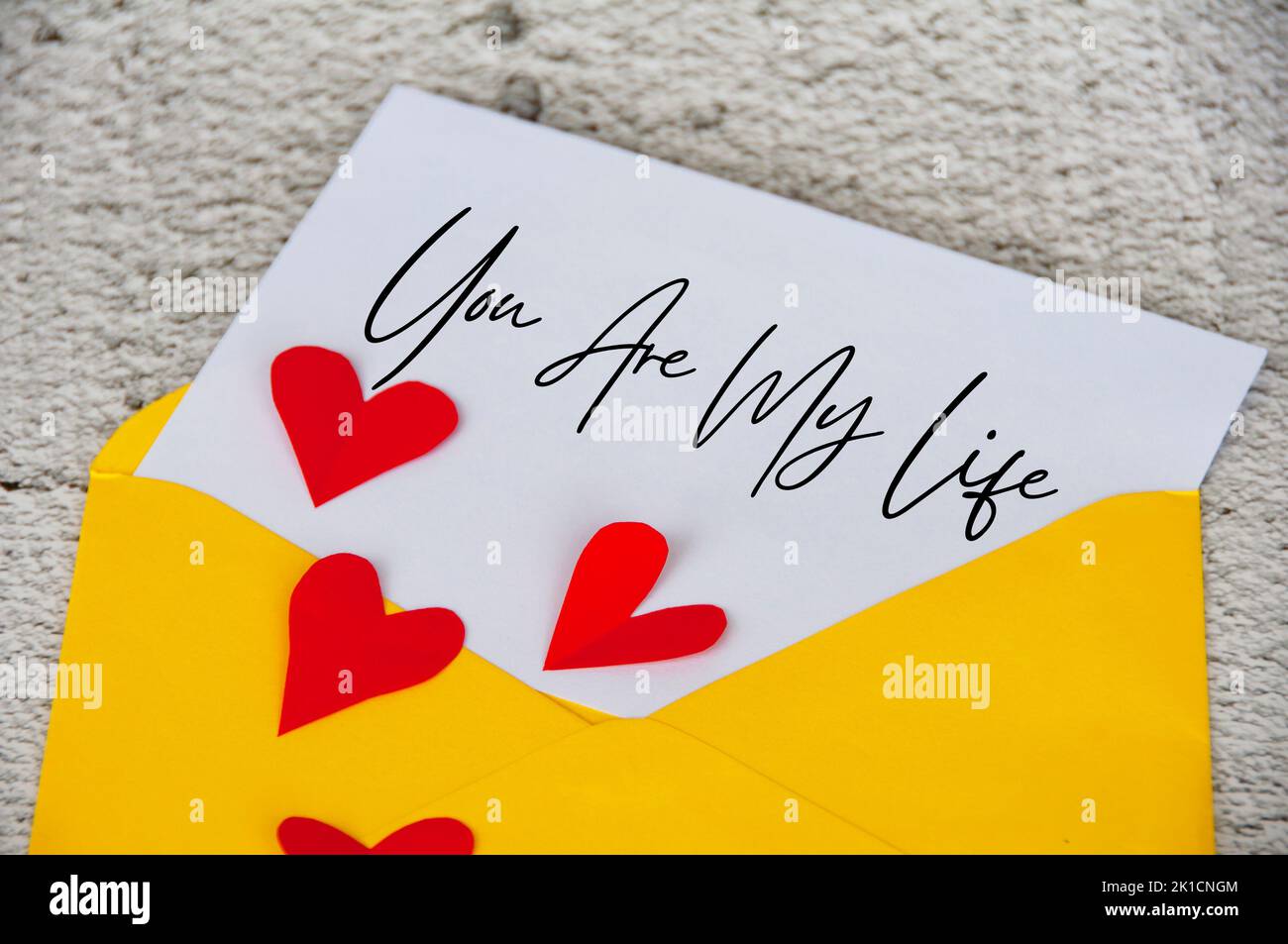 Du bist mein Lebenstext auf Notizblock in gelbem Umschlag, umgeben von Herzform. Romantik und Beziehungskonzept. Stockfoto