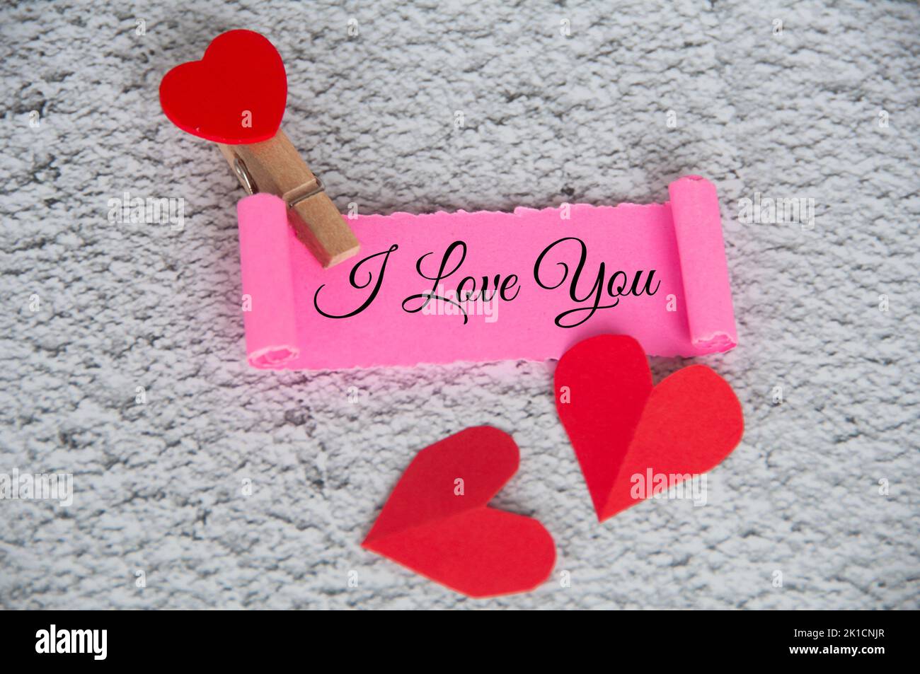 Ich liebe dich Text auf zerrissenem rosa Papier mit Tastatur Hintergrund. Romantik und Beziehungskonzept. Stockfoto