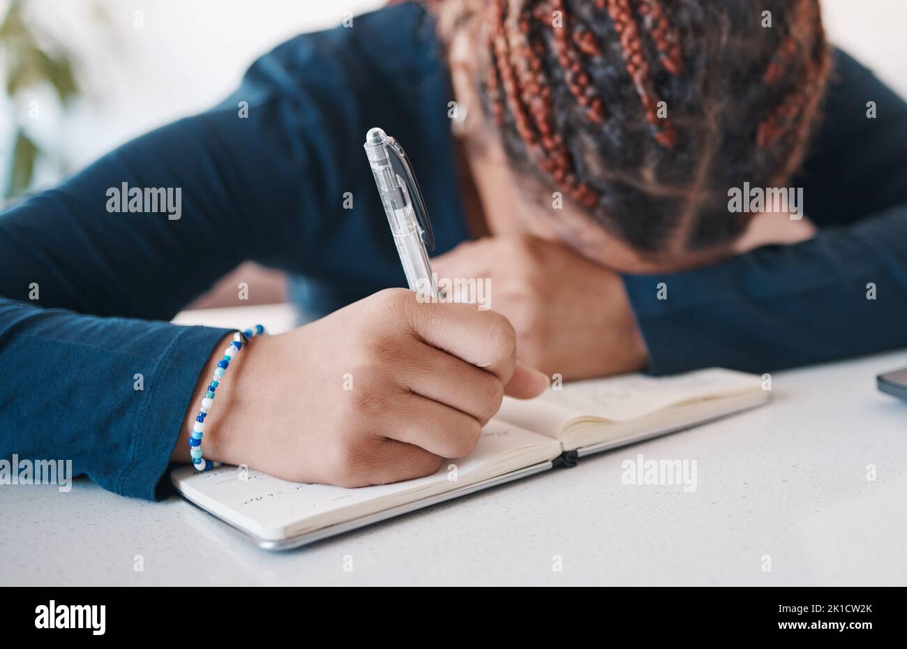 Hand, Schreiben und Notizbuch mit einer Autorin oder Schreiben, die unter Stress, Angst oder Burnout in ihrem Büro leidet. Mental, Schriftsteller blockieren und Müdigkeit mit einem Stockfoto