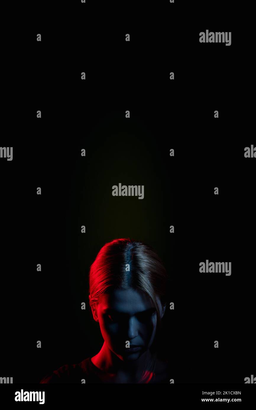 Weibliche Silhouette Porträt. Sozialer Druck. Erschöpfte Frau im Neonlicht glühen verbeugenden Kopf auf schwarz isoliert. Psychologische Unterstützung. Feststeckendes Problem. Kuppel Stockfoto