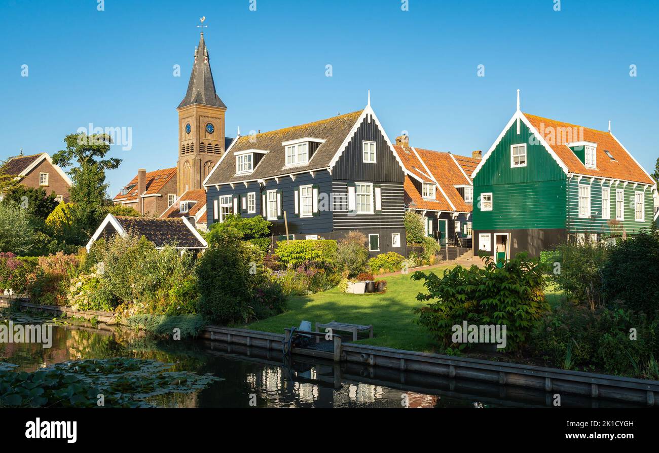 Holländisches touristisches Dorf Marken, Blick auf den Kirchturm und Holzhäuser entlang des Kanals Stockfoto