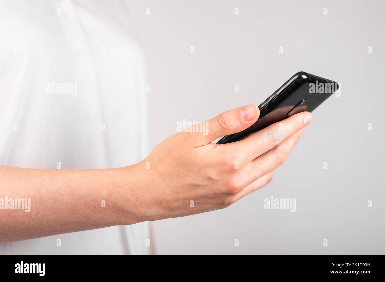 Frau hält das Telefon in der Hand. Verwendung des Geräts im Alltag. Profilansicht. Hochwertige Fotos Stockfoto