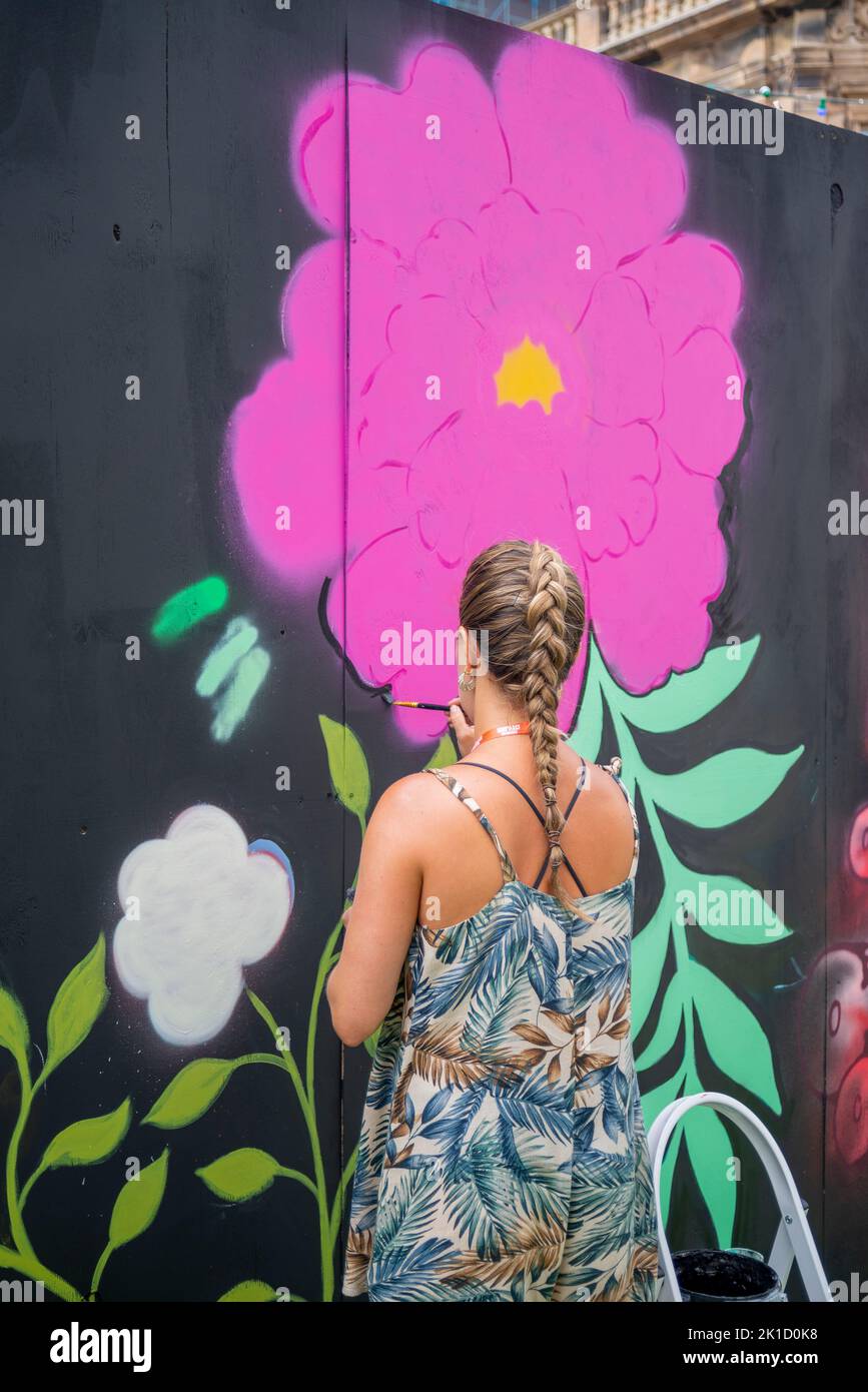 Veranstaltung „Southend City Jam“. Straßenkünstler, die ihr Können an 60 Orten im Stadtzentrum zeigen. Weibliche Malerei eine Blume in Blumenkleid Stockfoto